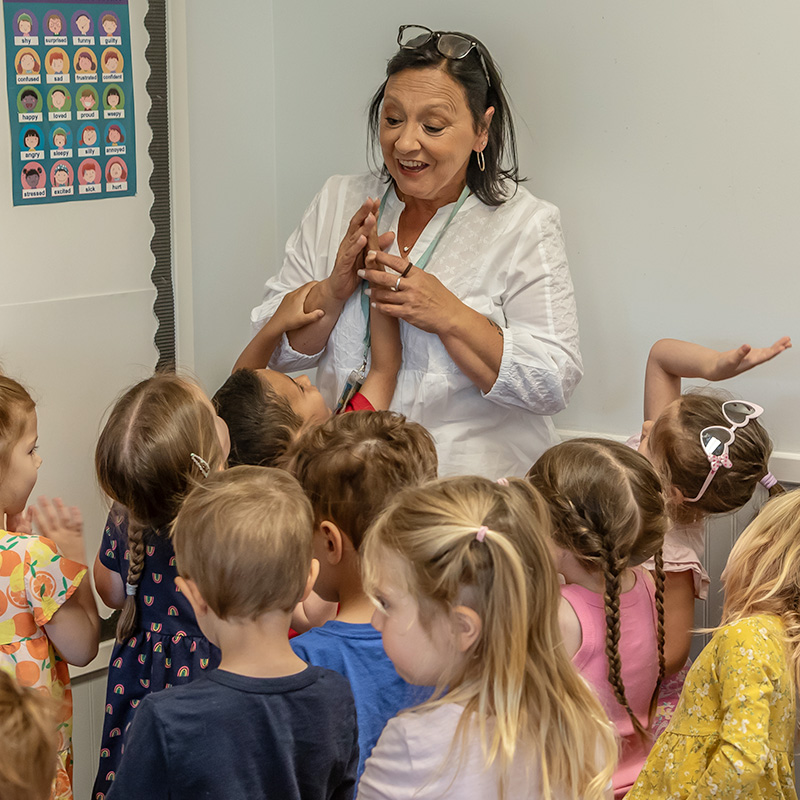 Teacher surrounded by preschool students
